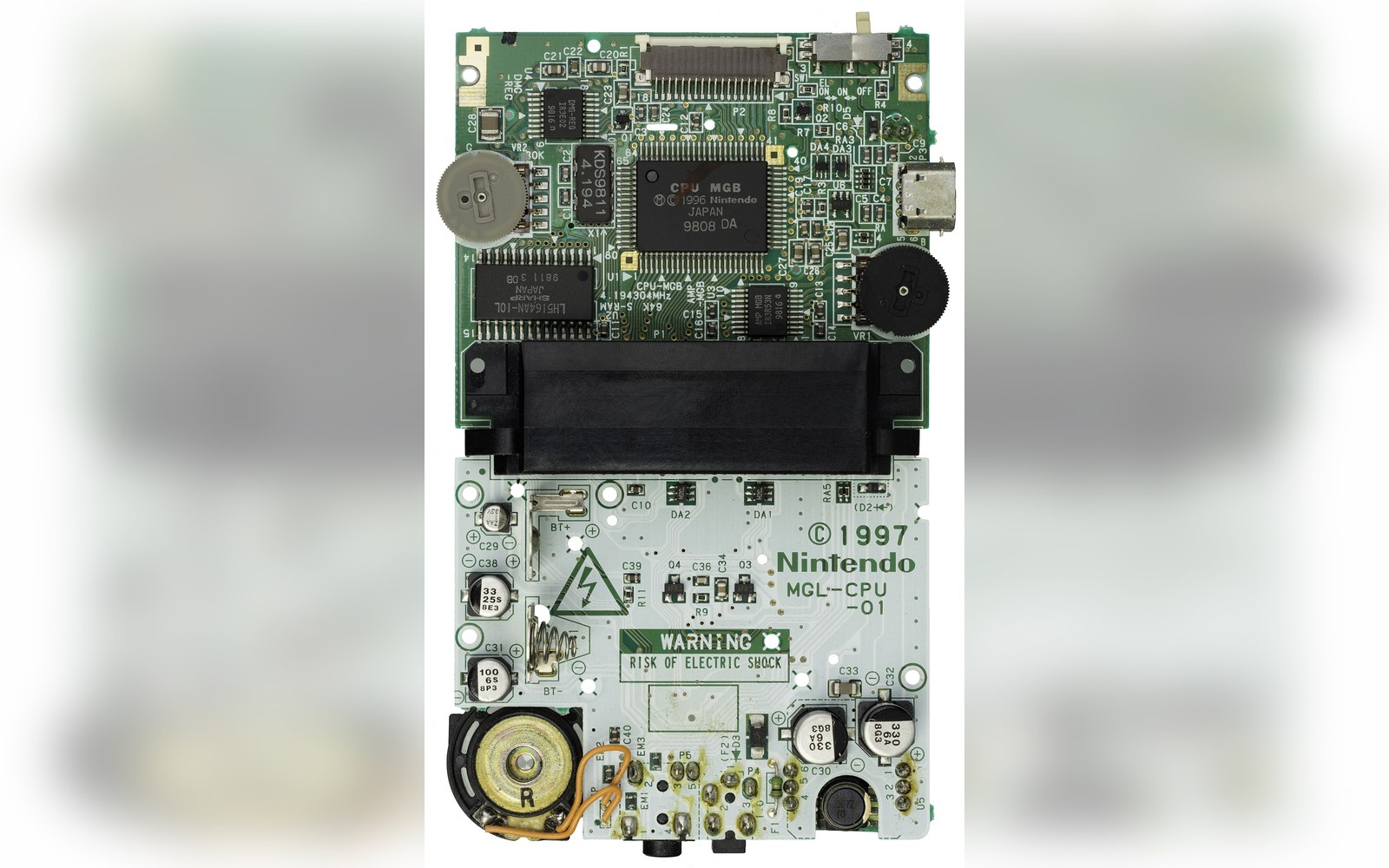 Circuit board of a Game Boy Light showing chips, speaker, capacitors and 1997 Nintendo markings